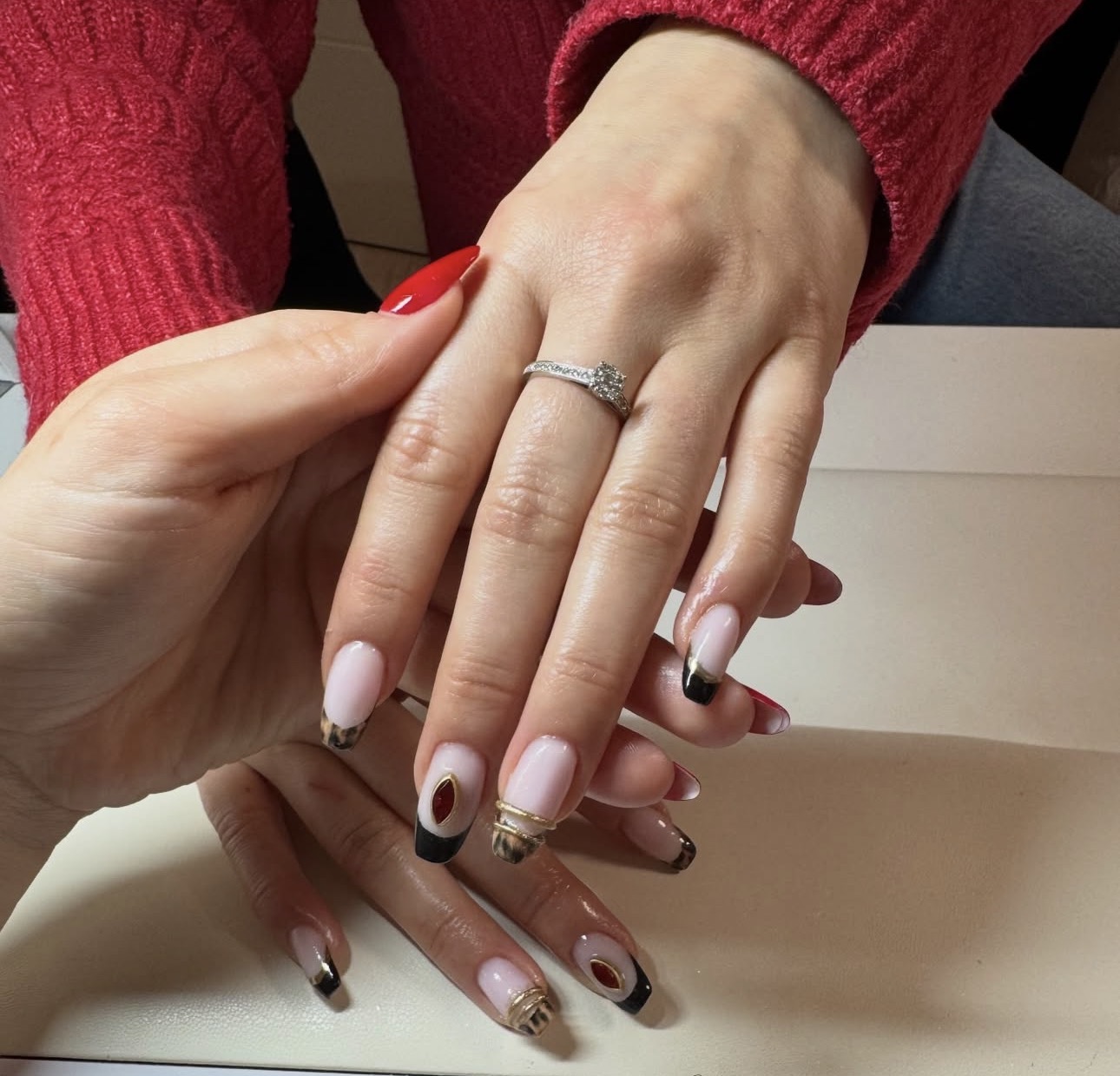 Nail Art mit schwarzen Spitzen, Goldakzenten und roten Details